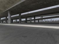 skateboarders are seen in an empty parking lot during the day on a cloudy day