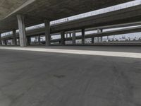 skateboarders are seen in an empty parking lot during the day on a cloudy day