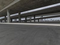 skateboarders are seen in an empty parking lot during the day on a cloudy day