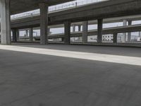 skateboarders are seen in an empty parking lot during the day on a cloudy day