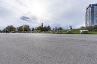 two skateboarders riding along an empty highway, the one is doing a trick