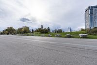 two skateboarders riding along an empty highway, the one is doing a trick