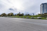 two skateboarders riding along an empty highway, the one is doing a trick