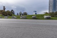 two skateboarders riding along an empty highway, the one is doing a trick