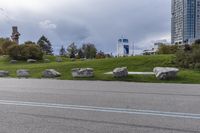 two skateboarders riding along an empty highway, the one is doing a trick