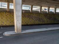 a man is skateboarding on an asphalt street in a city tunnelway near a building