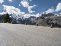 a man skateboarding down the middle of a road with some mountains in the background