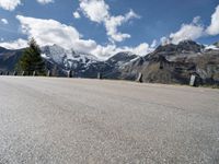 a man skateboarding down the middle of a road with some mountains in the background