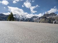 a man skateboarding down the middle of a road with some mountains in the background