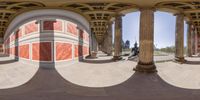 a fish eye lens view of a guy skateboarding down the walkway of a building