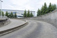 a boy skateboarding along an empty concrete road next to trees with gray and white clouds above