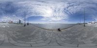 the skateboarder is practicing his tricks on the rail outdoors by the water's edge