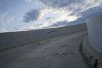 a man riding his skateboard on top of a ramp at a building on the edge of a large area