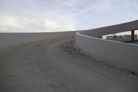 a man riding his skateboard on top of a ramp at a building on the edge of a large area