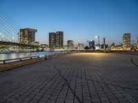 a man skateboarding on a walkway by the river with the cityscape in the background