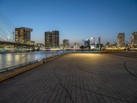 a man skateboarding on a walkway by the river with the cityscape in the background