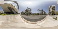 a skateboarder performs a trick on a half pipe in front of a large building