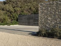 a skateboarder doing a jump off of a cement structure next to a stone wall