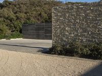 a skateboarder doing a jump off of a cement structure next to a stone wall