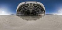 a half way view of a circular mirror and a skateboard ramp at an empty skating center