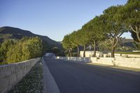 a young child is skateboarding along a wall in the middle of the road in the day