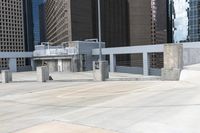 a skateboarder is on top of the cement area in a city setting with many skyscrapers