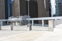 a skateboarder is on top of the cement area in a city setting with many skyscrapers