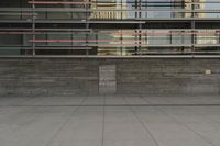 a man riding a skateboard through a cement covered parking lot under a building on a city street