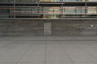 a man riding a skateboard through a cement covered parking lot under a building on a city street