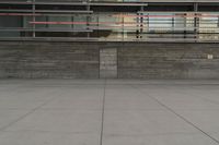 a man riding a skateboard through a cement covered parking lot under a building on a city street