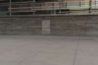 a man riding a skateboard through a cement covered parking lot under a building on a city street