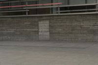 a man riding a skateboard through a cement covered parking lot under a building on a city street