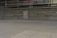 a man riding a skateboard through a cement covered parking lot under a building on a city street