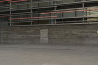 a man riding a skateboard through a cement covered parking lot under a building on a city street