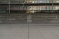 a man riding a skateboard through a cement covered parking lot under a building on a city street