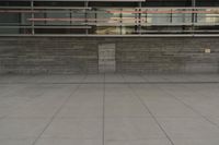 a man riding a skateboard through a cement covered parking lot under a building on a city street