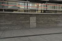 a man riding a skateboard through a cement covered parking lot under a building on a city street