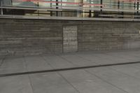 a man riding a skateboard through a cement covered parking lot under a building on a city street