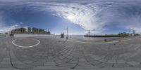 the panorama lens shows a man riding on skateboard at an intersection of a city plaza