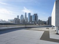 a man that is holding a skateboard up to a wall in the city of skyscrapers