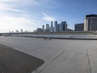 a man that is holding a skateboard up to a wall in the city of skyscrapers