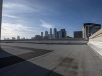 a man that is holding a skateboard up to a wall in the city of skyscrapers