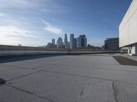 a man that is holding a skateboard up to a wall in the city of skyscrapers