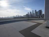 a man that is holding a skateboard up to a wall in the city of skyscrapers