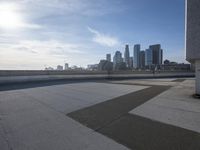 a man that is holding a skateboard up to a wall in the city of skyscrapers