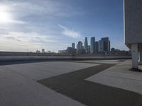 a man that is holding a skateboard up to a wall in the city of skyscrapers