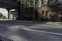 a man riding a skateboard down a sidewalk near a street under an overpass