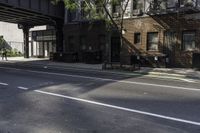 a man riding a skateboard down a sidewalk near a street under an overpass