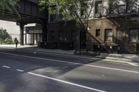 a man riding a skateboard down a sidewalk near a street under an overpass