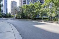 a car driving down an empty street lined with tall buildings and trees in the background